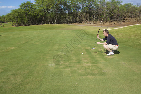 一名高尔夫球手在毛伊岛球场上推杆图片