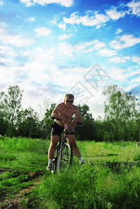 背景蓝天的骑自行车者图片