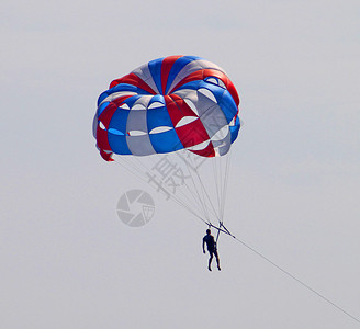 降落伞带着降落伞降落在蓝天上图片
