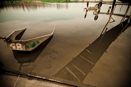 老旧被击毁的金属小船在湖图片
