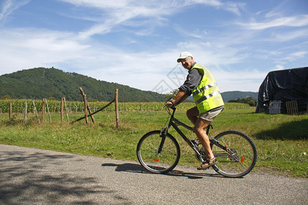 男退休骑自行车的男运动员在农村乘车穿图片