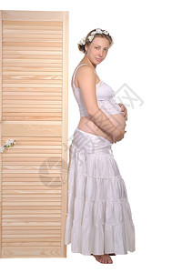 美丽的孕妇站在木栅图片