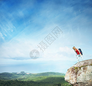 年轻女人站在悬崖边缘的背着图片