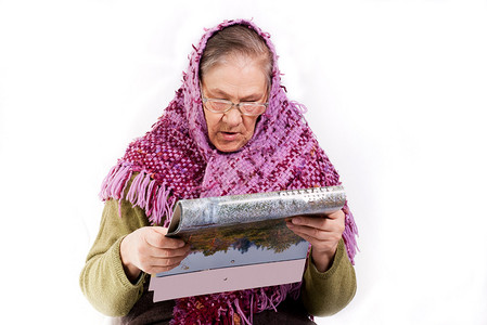 围巾的老妇人读杂志图片