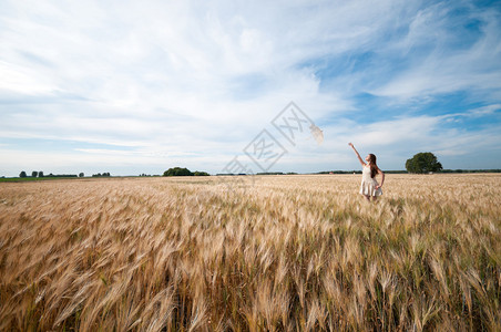 美丽的悲伤和孤独的女人带着伞在小麦田里行图片