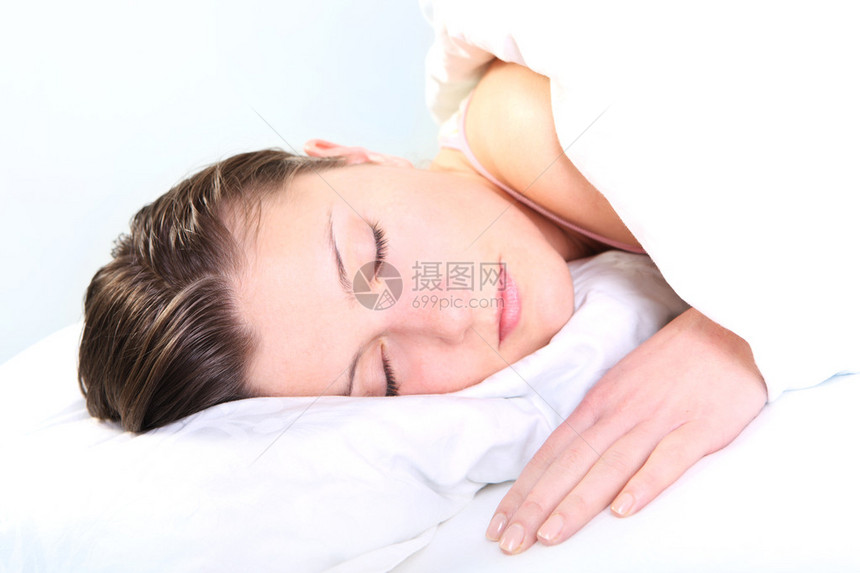 一张美丽的年轻女子在白色背景中睡觉的照图片