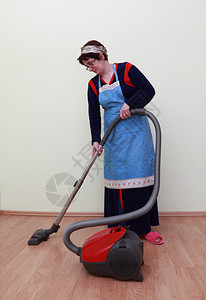 家庭主妇用吸尘器打扫地板图片