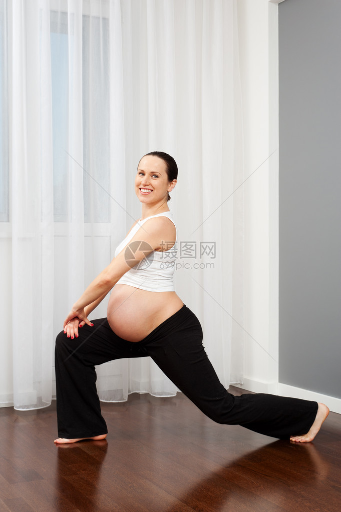 做伸展运动的健康年轻孕妇的肖像图片