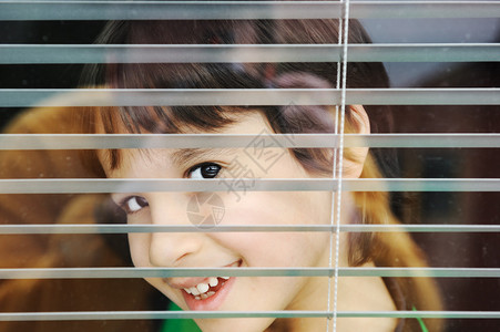 一个无辜的小男孩的肖像偷窥窗外和Ja图片
