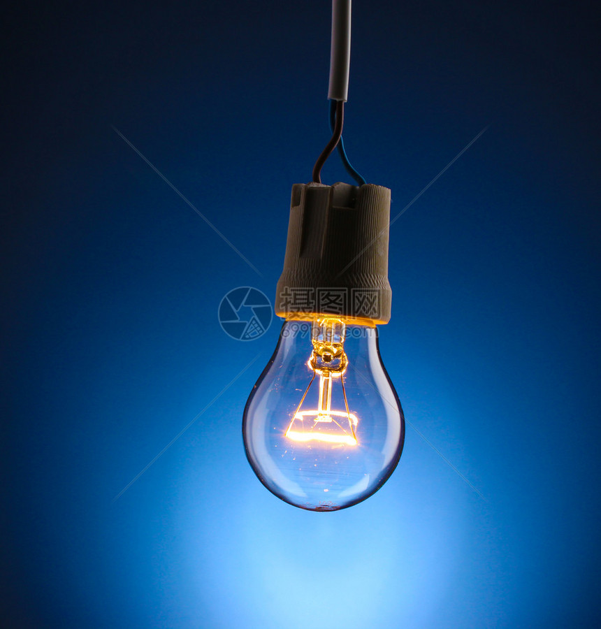 在蓝色背景的一个被点燃的电灯泡图片