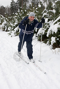男子在冬季森林滑雪图片