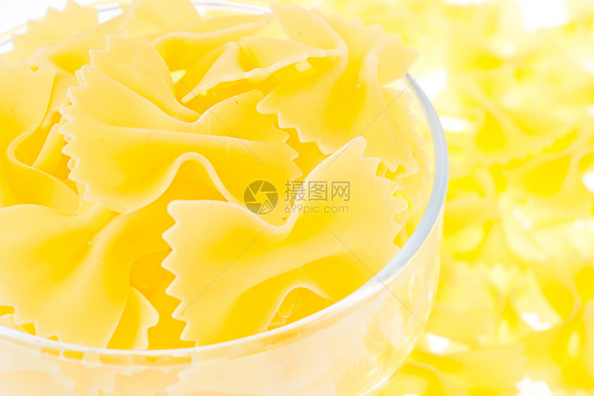 黄色背景面食玻璃杯中的黄色面条图片