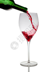 将红酒倒入白色隔离的玻璃高脚杯中图片