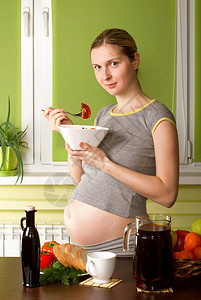 厨房里的孕妇吃西红柿图片