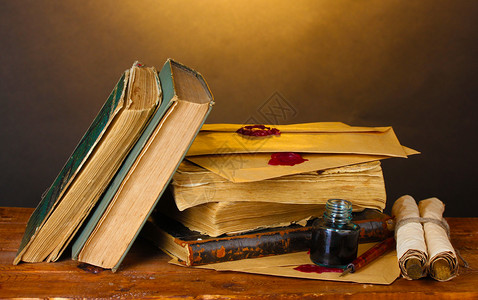 棕色背景的木桌上的旧书卷轴图片