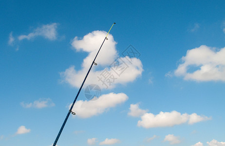 反对蓝天的垂直的钓鱼竿图片