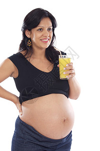 美丽的孕妇喝橙子汁在白色的图片