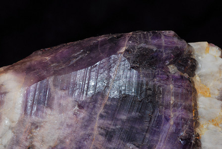明亮的紫色水晶矿物原料从采石场边缘钻出图片