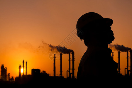 石油精炼厂工人日落时的剪影图片
