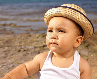 海滩上戴着草帽的婴儿图片