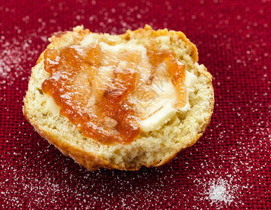 自制烤饼红桌布上加黄油和红果酱背景图片