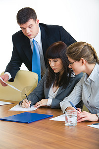 商业女商人在文件上与两名同事一图片