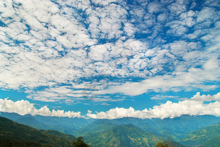 绿山与森林和蓝色多云的天空图片