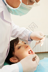 检查女孩牙齿的牙医图片