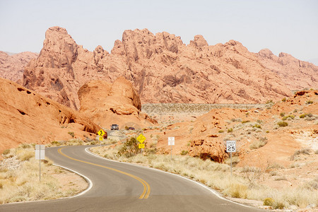 一辆卡车在红色的岩石峡谷和buttes穿过红岩峡谷的弯图片