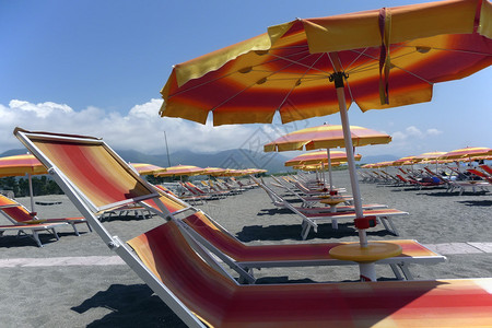 意大利海岸上靠近那不勒斯太阳雨伞甲板椅的空海滩大规模生产蓝色天空图片