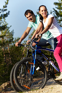 一对骑自行车的运动夫妇的肖像看着镜图片