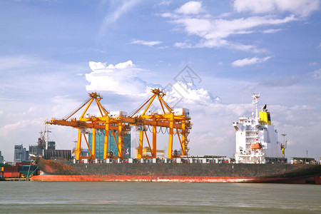 具有工作起重机桥卸货和装载货物的集装箱货运工业船在曼谷造船厂码头物图片