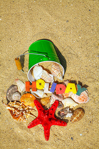 木制五颜六色的词假期与沙子上的贝壳图片