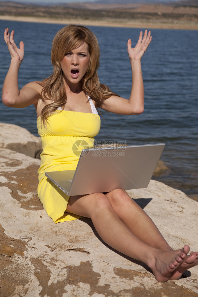 一位穿着太阳裙的女士正在放松并在她的电脑上工作图片
