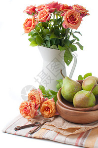 在白色背景上以橙色调的玫瑰和梨的安排图片