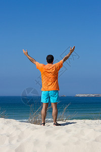 靠近大海的滩上的男人图片