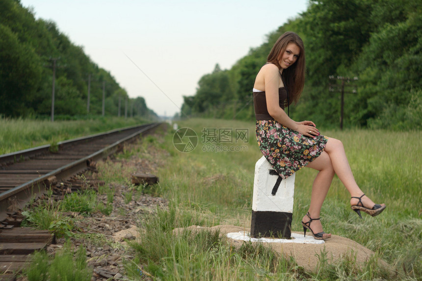 在铁路交通标志附近的年轻漂亮女孩表图片