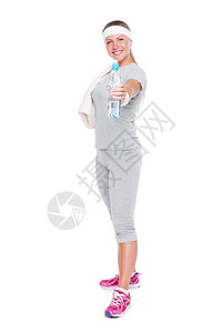 年轻健身女子拿着一瓶水满脸白面笑图片