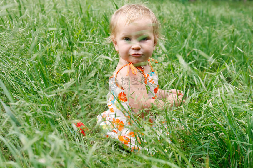 绿草中可爱的蹒跚学步的女孩图片