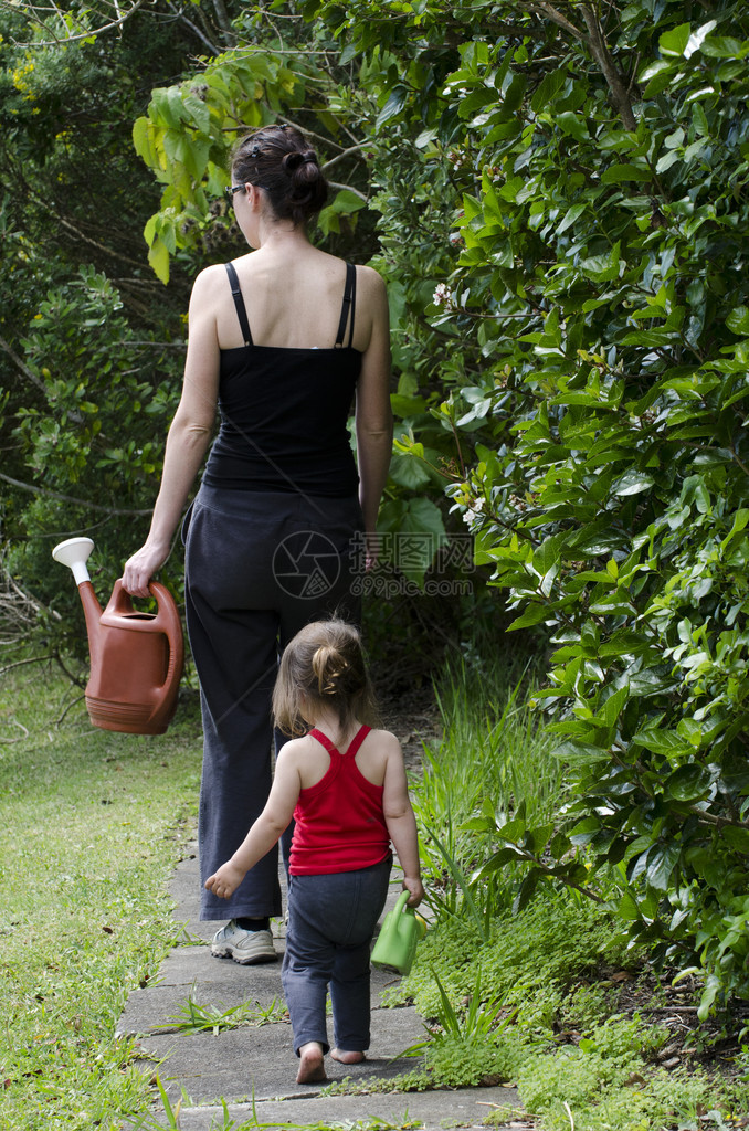 年轻母亲和女儿在花园里图片