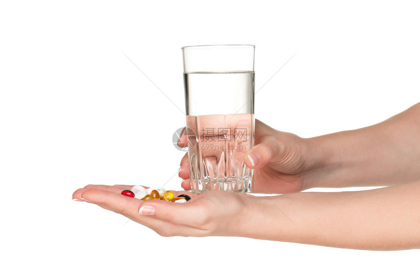 妇女手用药丸和玻璃杯水在白图片