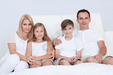 有两个孩子在卧室床的幸福家庭肖像Be图片