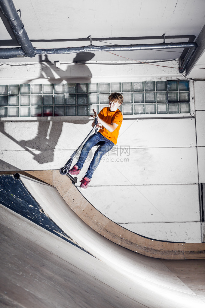 男孩在滑冰厅骑摩图片