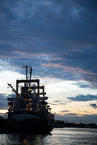 货船与港口资产相比晚上太阳下图片