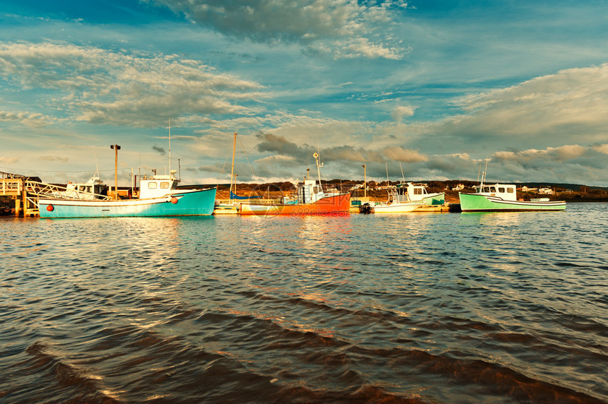 日落时在港口的渔船与戏剧天空图片