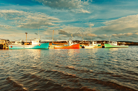 日落时在港口的渔船与戏剧天空图片