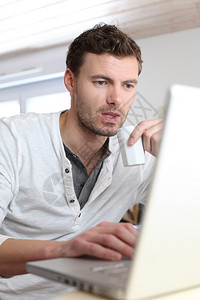 男人在笔记本电脑前喝咖啡图片