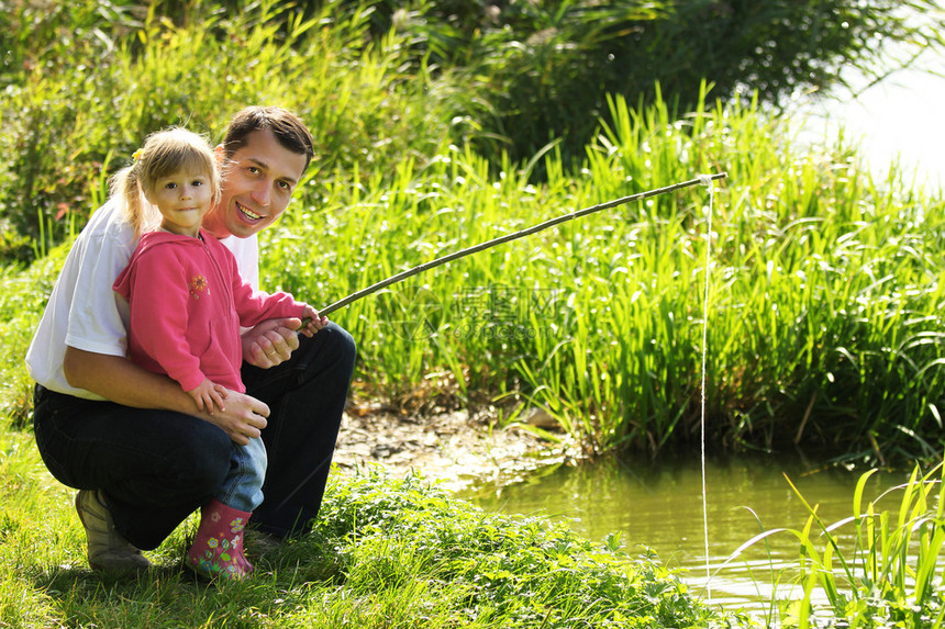 美丽的小女孩带着父亲在湖图片