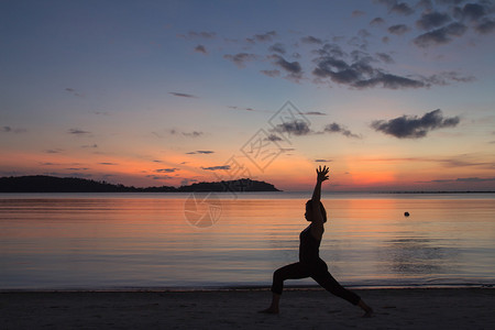 一个美丽的瑜伽女孩的月出在海滩上的日出图片