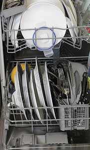 带白盘子和钢制餐具的洗碗机图片